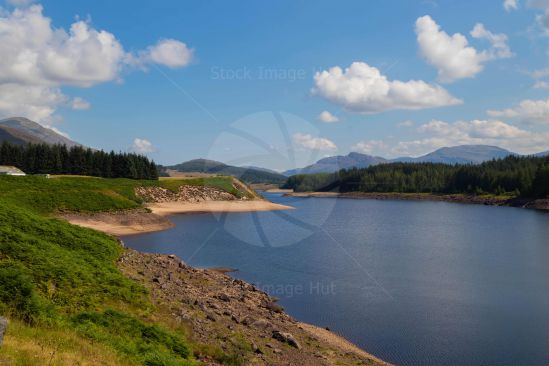 A beautiful loch in the North of Scotland on a sunny, warm day with mountains as a backdrop