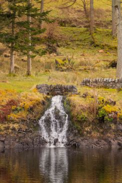 A very small waterfall coming from fields in winter image