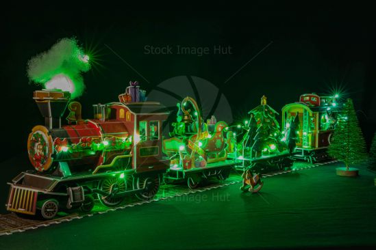 Christmas train model with fake steam and fairy lights sitting on track