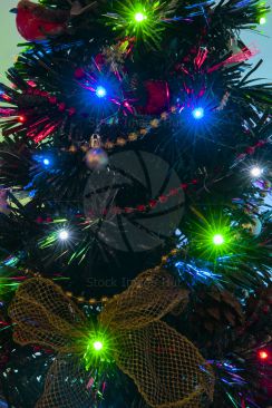 A close-up of a decorated Christmas tree with fairy lights as star bursts