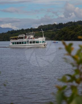 Small cruise boat, the Astina, cruising loch Lomond on a summers day