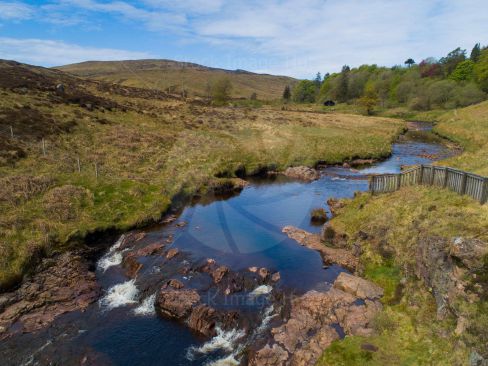 A winding river in the glens of Scotland from a drone