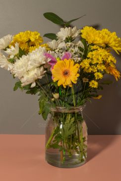 A coulorful bouquet of spring flowers in a clear vase of water