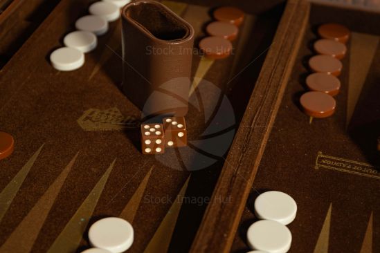 Close up shot of two dice sitting on a backgammon board game with backgammon chips image