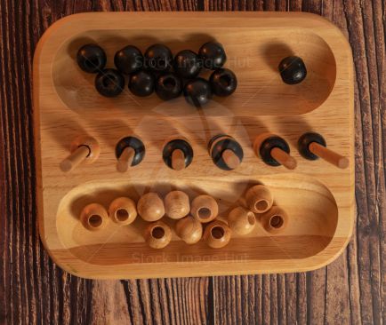 Looking straight down on an old style wooden game called four-in-a-row sitting on wooden background image