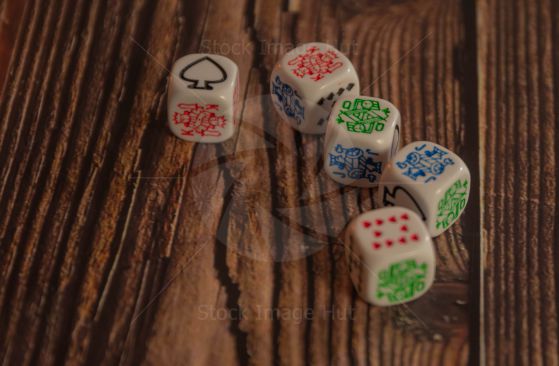 Popular poker dice game showing a run 10-jack-queen-king-ace sitting on wooden background image