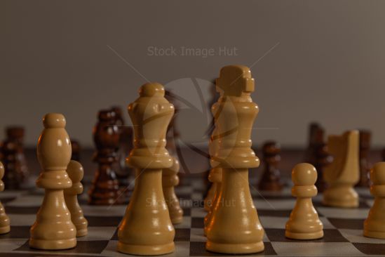 Close up shot of chess pieces sitting on chess board in very low light focusing on the King and Queen