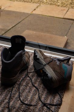 A pair of hiking boots lying at open door after a hike in the rain image