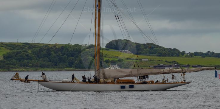 Crew lowering sails of massive yacht after regatta race