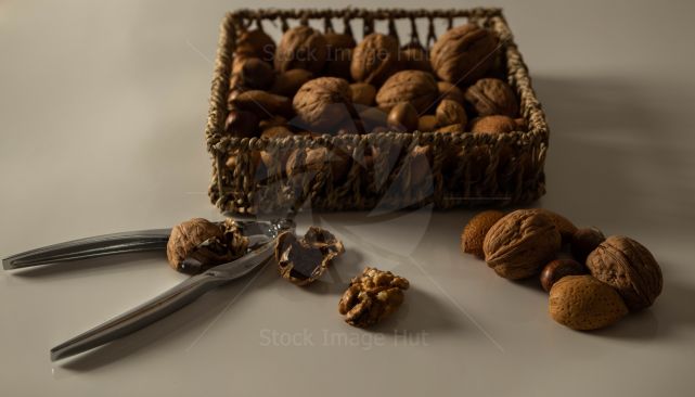 An assortment of nuts sitting on table with nut cracker image