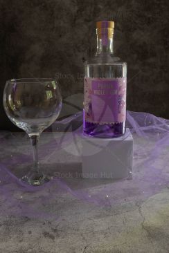 A bottle of violet gin and large gin glass