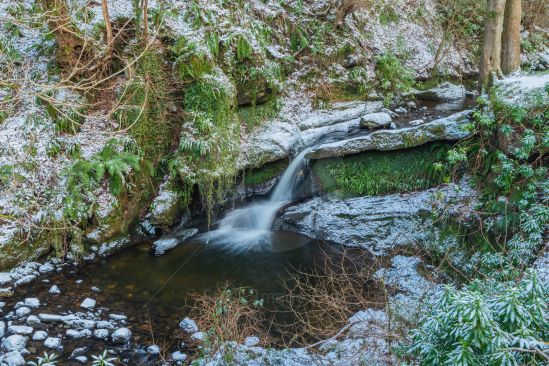 Small river with little waterfall in winter