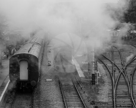 Classic old train station covered in steam from steam train just arrived image