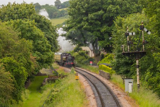 Old steam train just coming into view on tracks image